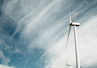 A wind turbine in front of a cloudy sky