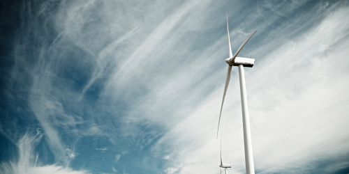 A wind turbine in front of a cloudy sky